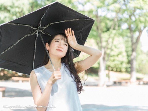 夏に熱中症・紫外線対策で日傘をさす女性